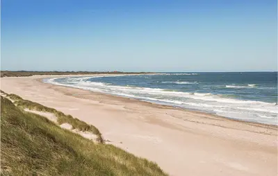 a sandy beach with the ocean in the background at 2 Bedroom Amazing Home In Hanstholm in Hanstholm