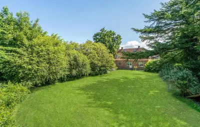 a large yard with a house in the background at 6 Bedroom Amazing Home In Roslev in Roslev