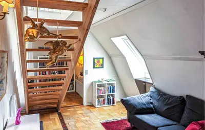 a living room with a book shelf and a staircase at 6 Bedroom Amazing Home In Roslev in Roslev
