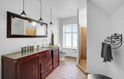 a bathroom with a sink and a toilet and a mirror at 6 Bedroom Amazing Home In Roslev in Roslev