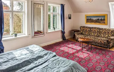 a bedroom with a bed and a couch and windows at 6 Bedroom Amazing Home In Roslev in Roslev