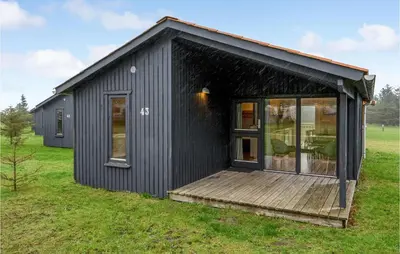 a black tiny house with a wooden deck at 2 Bedroom Nice Home In Hanstholm in Hanstholm