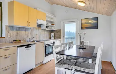 a kitchen with a table and a dining room at 2 Bedroom Nice Home In Hanstholm in Hanstholm