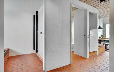 a room with white walls and a kitchen with a refrigerator at Gorgeous Apartment In Brovst With Wifi in Brovst