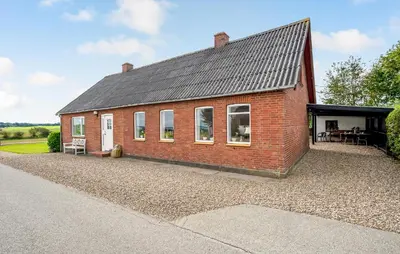 a red brick house on a gravel driveway at 2 Bedroom Gorgeous Home In Roslev in Roslev