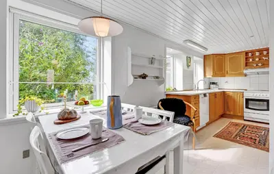 a kitchen with a table and a large window at 2 Bedroom Gorgeous Home In Roslev in Roslev