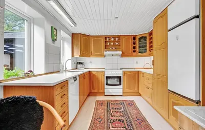 a kitchen with wooden cabinets and a rug on the floor at 2 Bedroom Gorgeous Home In Roslev in Roslev