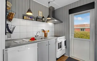 a kitchen with white cabinets and a sink and a window at Cozy Home In Hurup Thy With Wifi in Doverodde