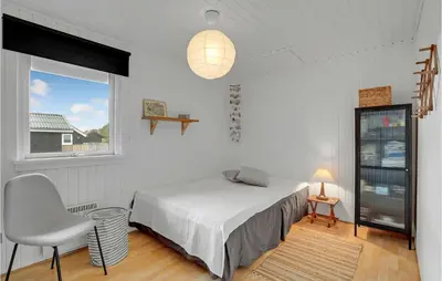 a bedroom with a bed and a chair and a window at Cozy Home In Hurup Thy With Wifi in Doverodde