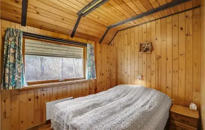 a bedroom with a bed in a wooden cabin at 4 Bedroom Pet Friendly Home In Løgstør in Løgstør