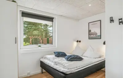 a bed in a room with a window at Lovely Home In Thisted With Sauna in Thisted