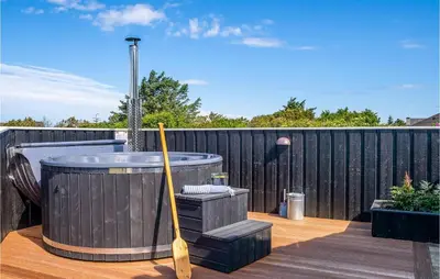 a wooden deck with a hot tub and a baseball bat at 3 Bedroom Lovely Home In Vestervig in Vestervig