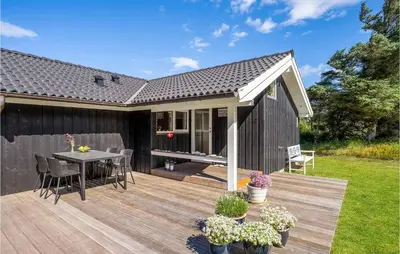a wooden deck with a table and chairs at 3 Bedroom Lovely Home In Vestervig in Vestervig
