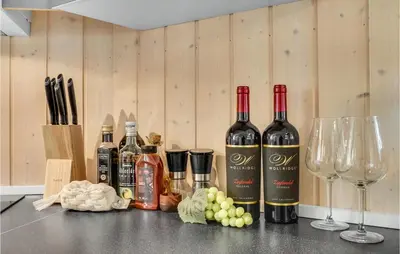 three bottles of wine sitting on a counter with wine glasses at 3 Bedroom Lovely Home In Vestervig in Vestervig