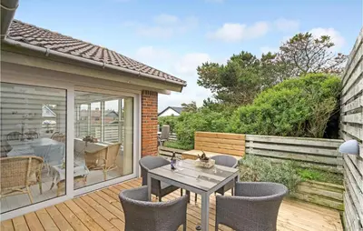a patio with a table and chairs on a deck at Gorgeous Home In Thisted in Torsted