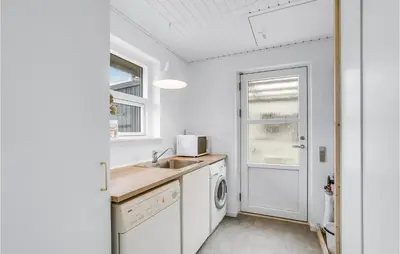 a kitchen with a sink and a washing machine at Gorgeous Home In Thisted in Torsted