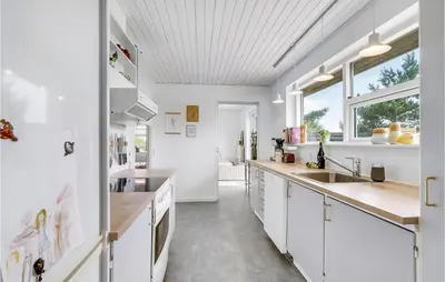 a kitchen with white cabinets and a sink at Gorgeous Home In Thisted in Torsted