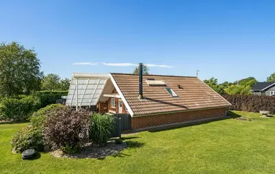 a house with a roof on top of a yard at Stunning Home In Roslev With Kitchen in Roslev