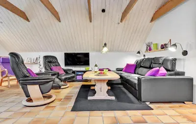 a living room with black leather furniture and a table at Stunning Home In Roslev With Kitchen in Roslev