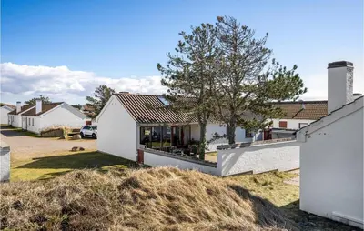 a house with white walls and a tree at Beautiful Home In Pandrup With Wifi in Pandrup