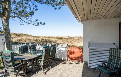 a table and chairs on a patio with a view of the ocean at Beautiful Home In Pandrup With Wifi in Pandrup