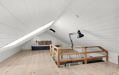 a attic room with a bed and a lamp at Beautiful Home In Pandrup With Wifi in Pandrup