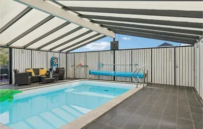 a swimming pool with a pergola and a swimming pool at Nice Home In Blokhus With Sauna in Blokhus