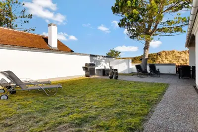 a patio with chairs and a tree next to a building at Beautiful Home In Pandrup With 2 Bedrooms And Wifi in Pandrup