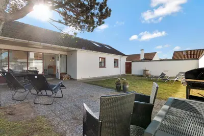 a patio with chairs and a table in a yard at Beautiful Home In Pandrup With 2 Bedrooms And Wifi in Pandrup