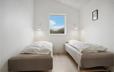 two beds in a room with a window at Nice Home In Thisted With Sauna in Thisted