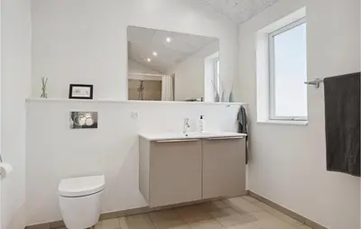 a white bathroom with a toilet and a sink at Nice Home In Thisted With Sauna in Thisted
