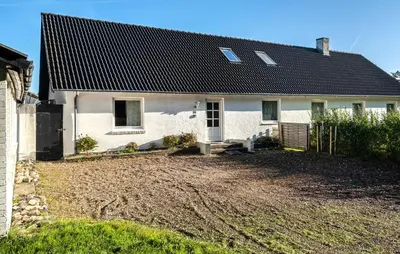 a white house with a black roof and a yard at 2 Bedroom Gorgeous Apartment In Pandrup in Pandrup