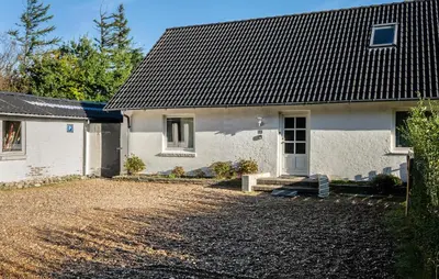 a white house with a black roof and a driveway at 2 Bedroom Gorgeous Apartment In Pandrup in Pandrup