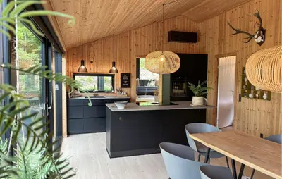 a kitchen and dining room with a table and chairs at 3 Bedroom Cozy Home In Blokhus in Blokhus