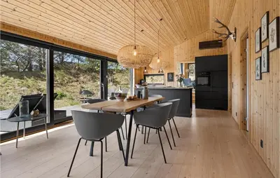 a kitchen and dining room with a table and chairs at 3 Bedroom Cozy Home In Blokhus in Blokhus