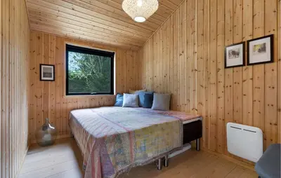a bedroom with a bed in a wooden room at 3 Bedroom Cozy Home In Blokhus in Blokhus