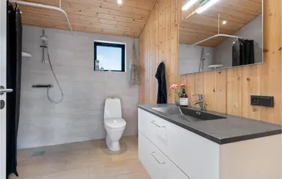 a bathroom with a sink and a toilet at 3 Bedroom Cozy Home In Blokhus in Blokhus