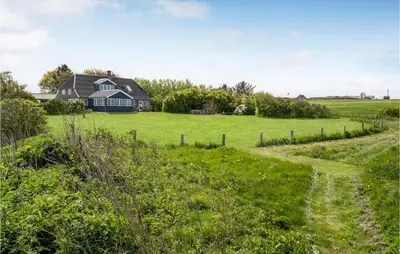 a house in the middle of a field with a dirt road at Beach Front Home In Lemvig With Wifi in Lemvig