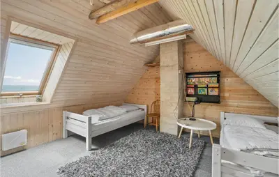 a room with two beds and a table at Beach Front Home In Lemvig With Wifi in Lemvig