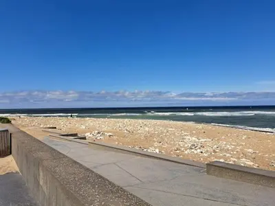 a beach with rocks and the ocean on a sunny day at 6 person holiday home in Thisted-By Traum in Torsted