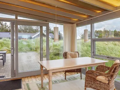 a dining room with a table and a large window at 6 person holiday home in Thisted-By Traum in Torsted