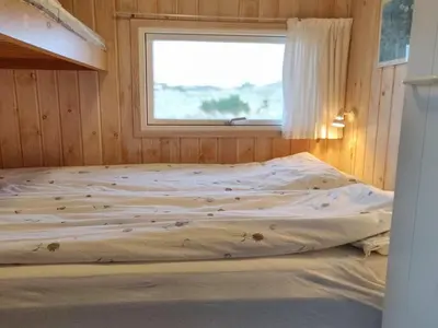 a bed in a room with a window at Holiday Home Syni - 500m from the sea by Interhome in Pandrup