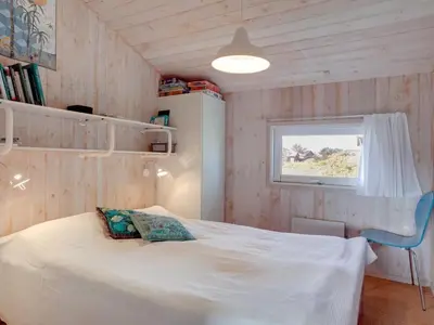 a bedroom with a white bed and a window at Holiday Home Syni - 500m from the sea by Interhome in Pandrup