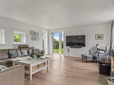 a living room with a couch and a tv at Holiday Home Kiersten - 5km from the sea by Interhome in Saltum