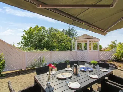 a wooden table with chairs and a gazebo at Holiday Home Kiersten - 5km from the sea by Interhome in Saltum