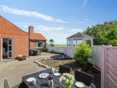 a patio with a table and chairs in a yard at Holiday Home Kiersten - 5km from the sea by Interhome in Saltum