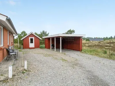 a red and white building next to a house at Holiday Home Lisemarie - 800m from the sea by Interhome in Torsted