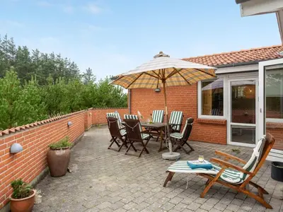 a patio with a table and chairs and an umbrella at Holiday Home Lisemarie - 800m from the sea by Interhome in Torsted