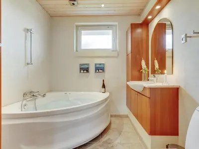 a bathroom with a large tub and a sink at Holiday Home Lisemarie - 800m from the sea by Interhome in Torsted