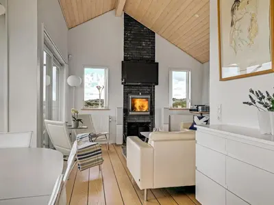 a living room with a couch and a fireplace at Holiday Home Ejvind - 100m from the sea by Interhome in Saltum